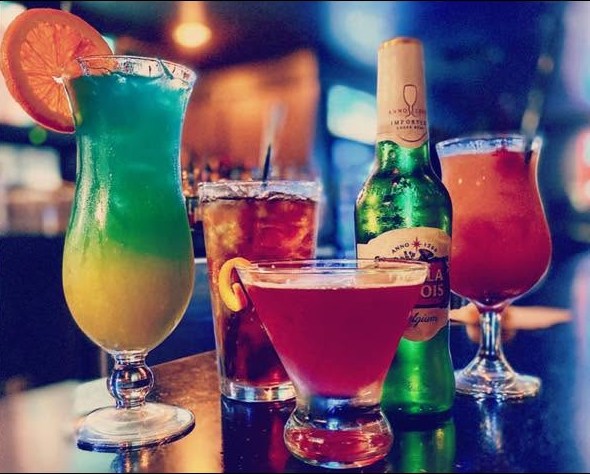 Cocktails and a cold beer lined up along the bar